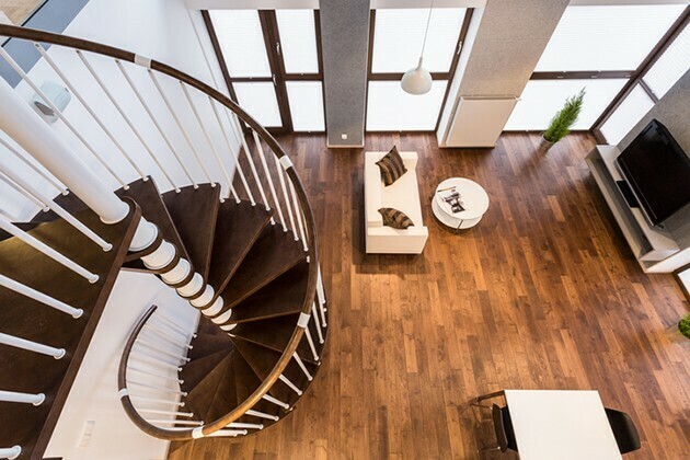 Curve wooden stairs in spacious living room | McSwain Carpet & Floors