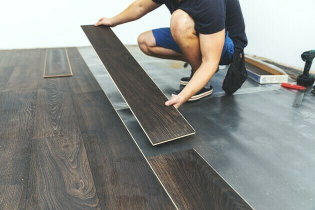 laminate flooring - worker installing new floor | McSwain Carpet & Floors