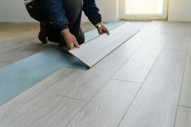 Worker carpenter doing laminate floor work | McSwain Carpet & Floors